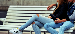 Two young people sitting on bench